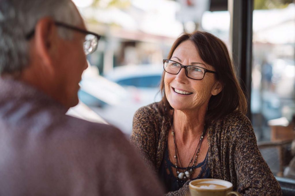 Couple happily talking in northern rivers cafe after an appointment at northern rivers audiology
